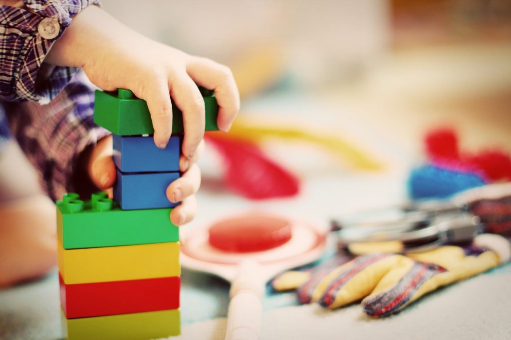 Kind setzt große Legosteine zusammen.Das Bild steht für die Behandlungsmethode Neurofeedback in Bühl.
